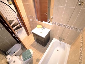 Un bagno con WC, bidet, lavandino e vasca da bagno.