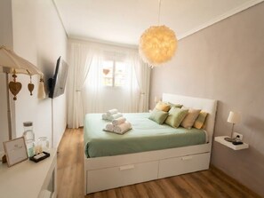 Et pænt møbleret soveværelse med seng, natbord og en hængende lampe.