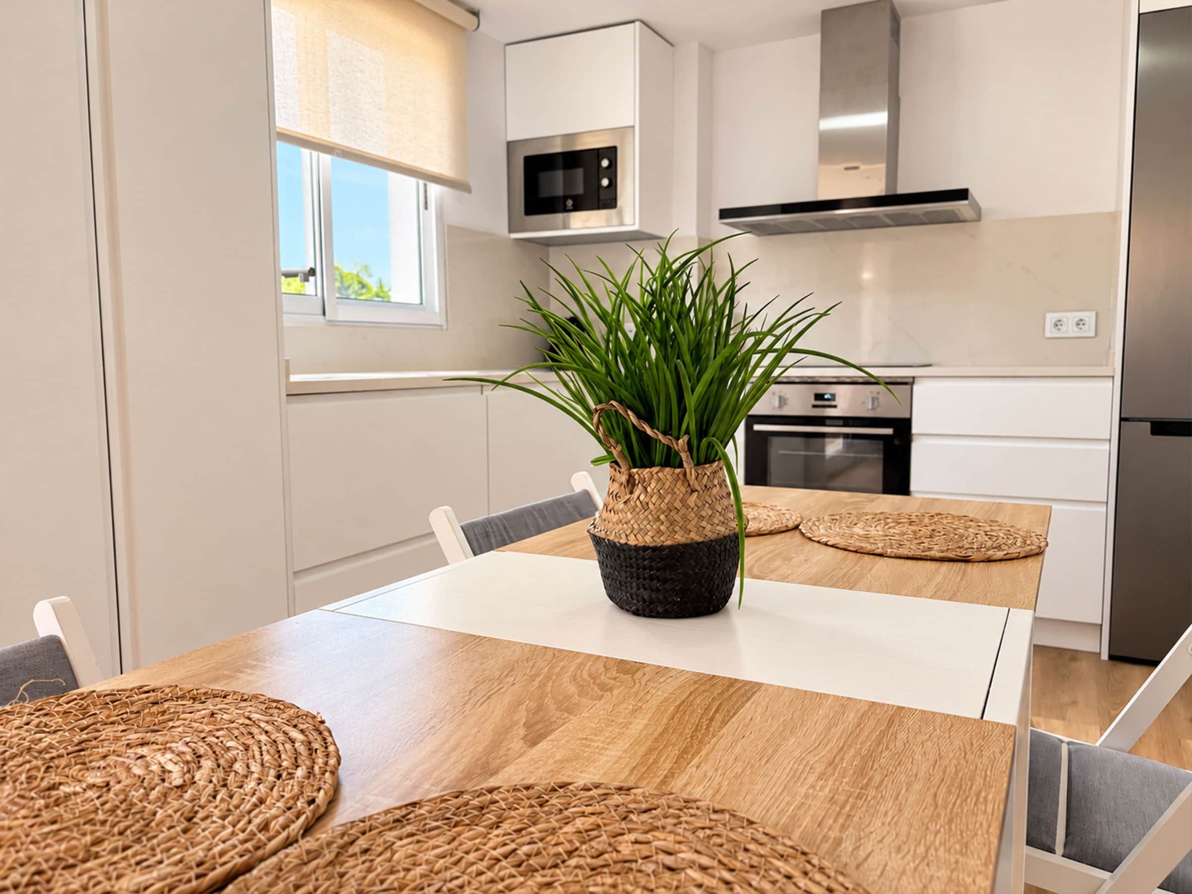 Una cocina moderna con una mesa de comedor, sillas, microondas y estufa.