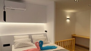 Een moderne slaapkamer met een bed, nachtkastjes, een hanglamp en een ingebouwde bank.