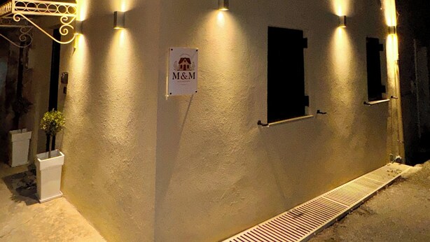 Een gebouw met een bord waarop 'M&M' staat en een klein raam.