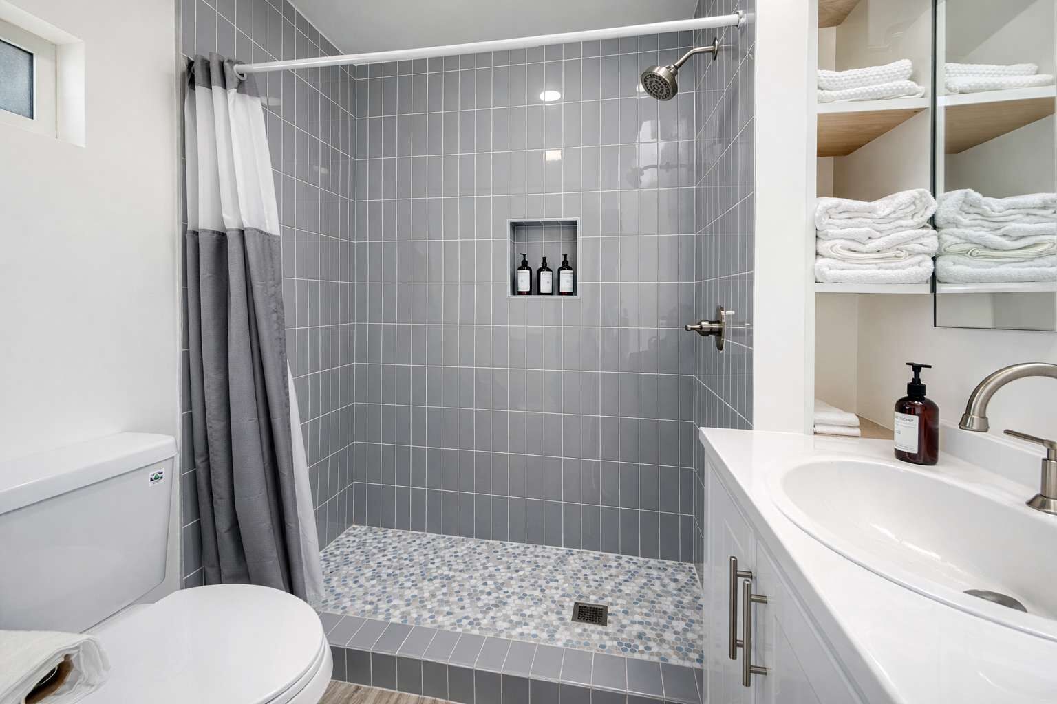 Une salle de bain moderne équipée d’une douche, de toilettes et d’un lavabo.