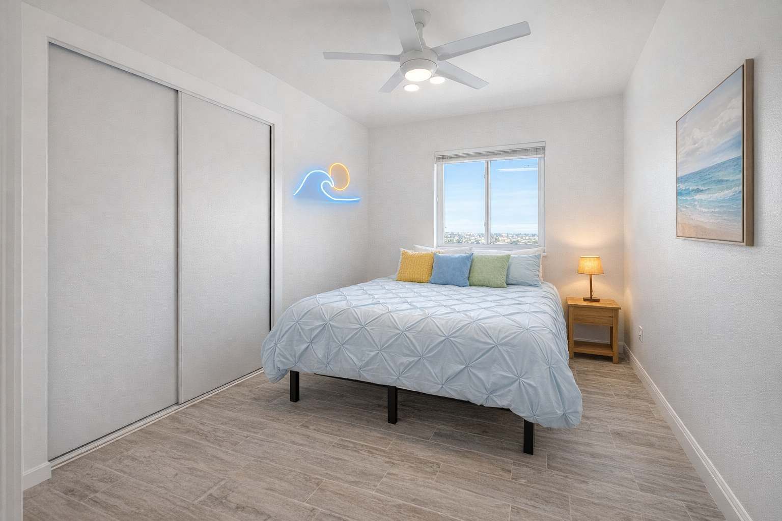 A bedroom with a bed, a ceiling fan, a window, and a nightstand.
