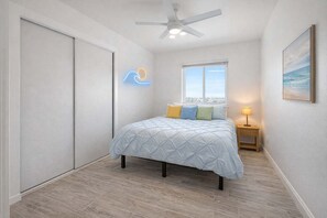 A bedroom with a bed, a ceiling fan, a window, and a nightstand. - Newly Redone Bayview Apt Steps to Bay & Boardwalk (San Diego)