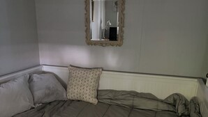 Ein Schlafzimmer mit einem großen Bett, einem Spiegel an der Wand und einem Heizkörper darunter.