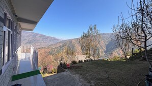 Ein Gebäude mit einem Balkon mit Blick auf eine gebirgige Landschaft.