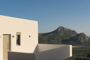 A modern building with a flat facade, a door with a decorative pattern, and a small window. - Aitherion – Villa with Pool & Upper Suite, Plakias (Τοπική Κοινότητα Ασωμάτου)
