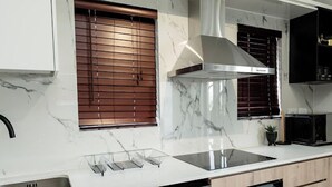 Uma cozinha moderna com máquina de lavar louça embutida, forno e exaustor de aço inoxidável.