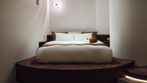 Ein Bett mit Kopfteil, Nachttisch und Beistelltisch.