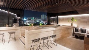 Um interior moderno com ilha de cozinha, banquetas de bar e um sofá.