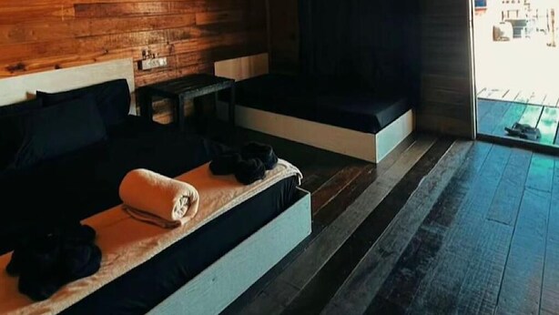A room with a bed, a bench, and a small table. - SEA WIN HOLIDAY (Mabul Island)
