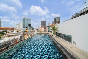 A rooftop swimming pool with a checkered tile pattern, surrounded by modern buildings and a clear sky. - Ekkamai Sukhumvit 65, Pet Friendly, 900m to BTS (กรุงเทพมหานคร)