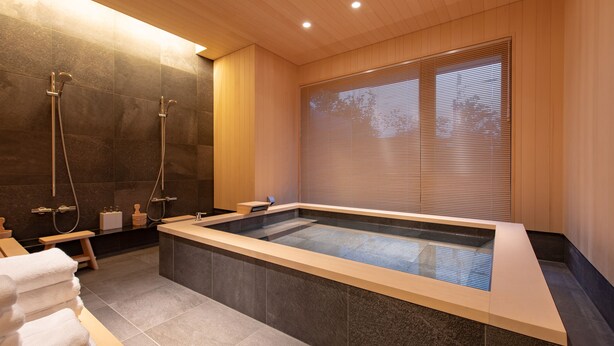 Ein modernes Badezimmer mit einer großen Badewanne, Dusche und Holzelementen.
