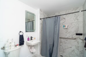 A bathroom with a toilet, sink, and shower curtain.