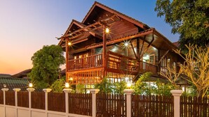 A traditional wooden building with multiple balconies and a wooden fence in front.