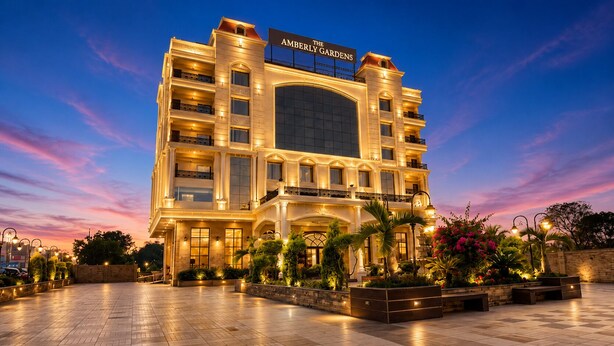 A multi-story hotel with a large entrance, balconies, and a well-lit facade. - The Amberly Gardens (Sanwer)