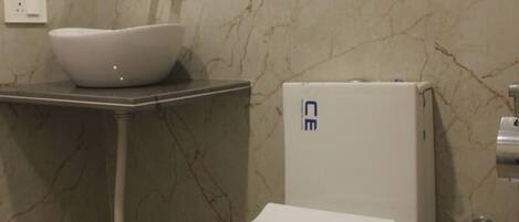 Un baño con inodoro, lavamanos y espejo.