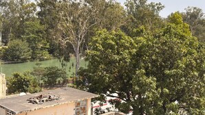 A view of a river with trees and a building with a flat roof.