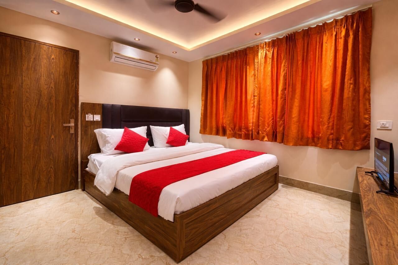 Una habitación de hotel con una cama grande, un armario de madera, un aire acondicionado y una televisión.
