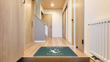 Un pasillo con paredes de madera, una alfombra de bienvenida y un radiador.