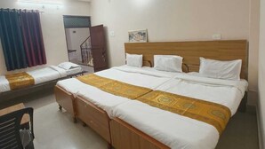 Una habitación de hotel con una cama grande, un ventilador de techo, un escritorio pequeño y una silla.