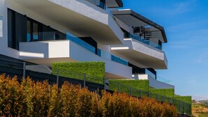 Een modern meerlaags gebouw met balkons en een heldere lucht.