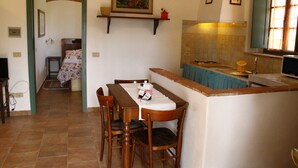 Un comedor con una mesa, sillas, mostrador de cocina y un lavabo.