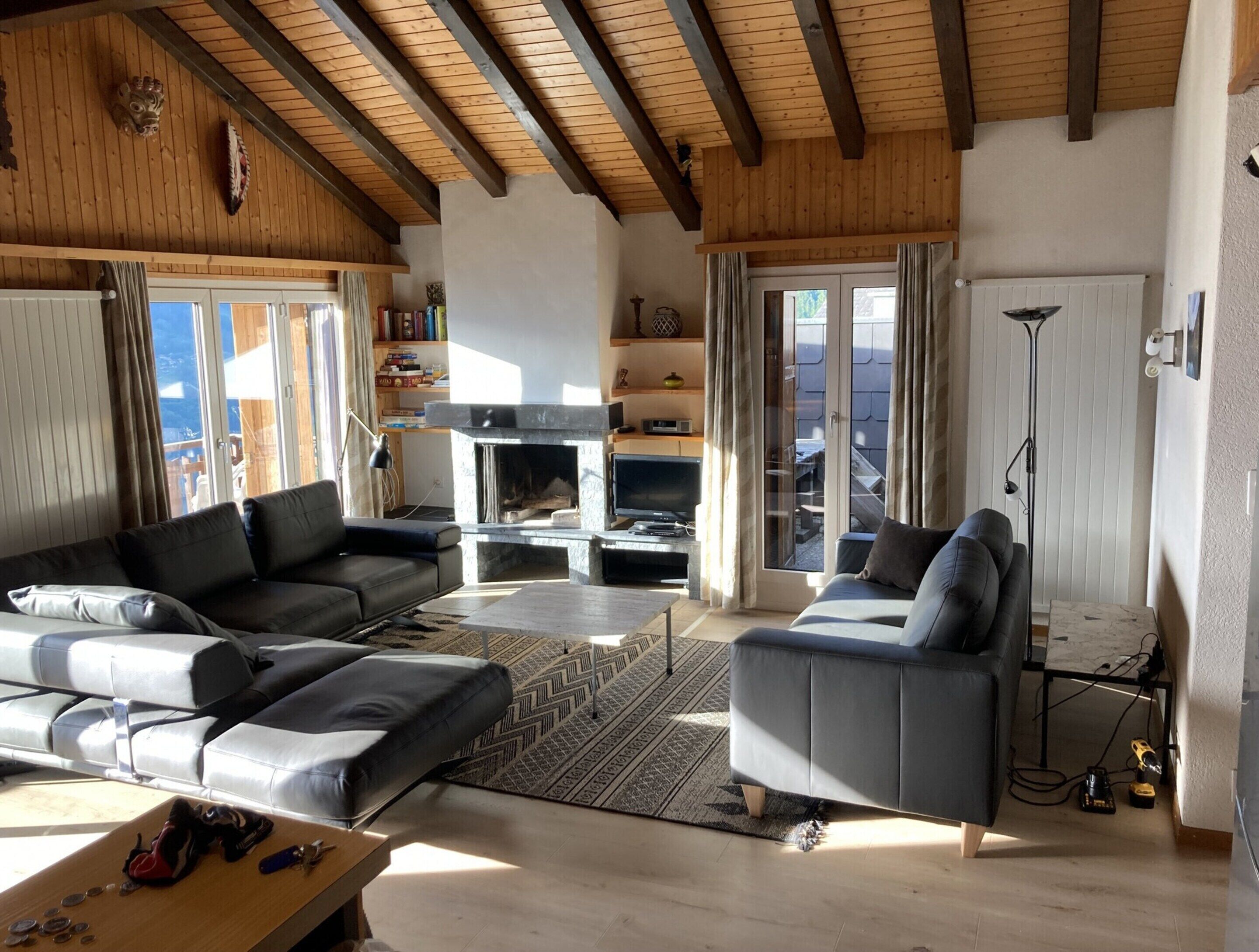 A spacious living room with a fireplace, two sofas, a television, and a bookshelf.