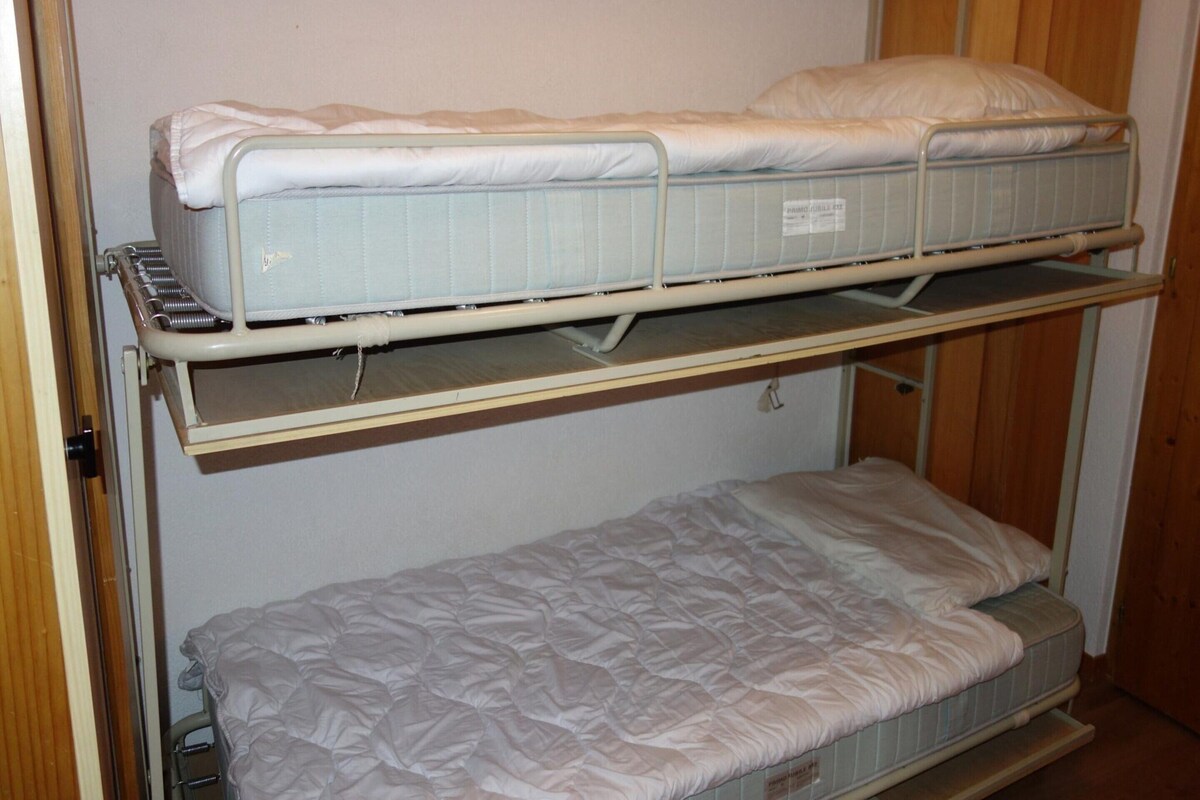 A bunk bed with a mattress and a lower bunk.