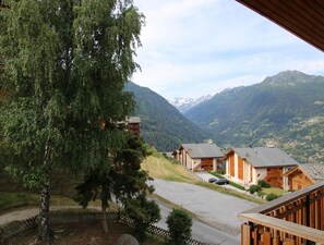 Eine Berglodge mit Holzhütten, einer Holzterrasse und Blick auf die umliegenden Berge.