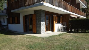 A modern two-story house with a stone facade, large glass doors, and a wooden balcony. - Cozy Apartment for Groups (Sion)