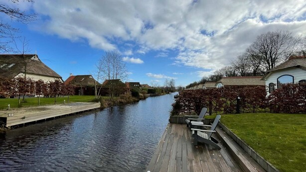A canal with wooden walkways and benches, surrounded by houses with traditional architecture. - Home in the Historic Sint Nicolaasga (Sint Nicolaasga)