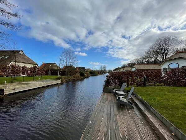 A canal with wooden walkways and benches, surrounded by houses with traditional architecture. - Home in the Historic Sint Nicolaasga (Sint Nicolaasga)