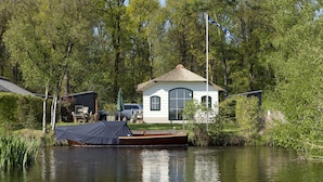 A house with a thatched roof, a dock, and a boat. - Home in the Historic Sint Nicolaasga (Sint Nicolaasga)