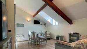 Ein Loft-Zimmer mit Essbereich, einem Bett und einem Fernseher.