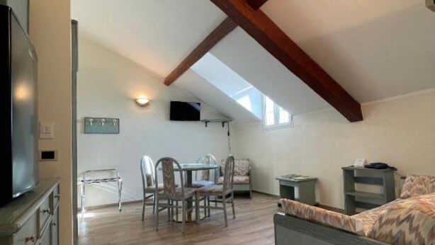Une pièce de style loft comprenant un coin repas, un lit et un téléviseur.