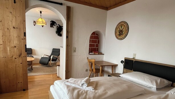 A hotel room with a bed, a desk, a chair, and a small table. - Apartment Saalfelden 23 (Saalfelden am Steinernen Meer)
