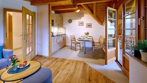 A wooden interior with a dining area, kitchen, and seating space. - Vacation apartment Sonnenblume, up to 2 persons, top floor, 50 sqm (Waging am See)