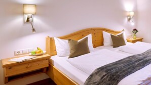 A neatly made bed with white linens, a wooden headboard, and two bedside lamps. - Vacation apartment Gänseblümchen, up to 2 persons, first floor, 50 sqm (Waging am See)