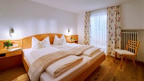 Et hotelværelse med en stor seng, sengeborde, en stol og en radiator.