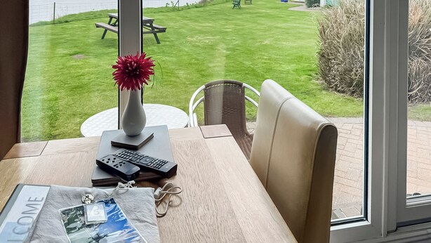 Huone, josta on näkymä merelle, nurmialue piknikpöydällä ja pieni varasto.