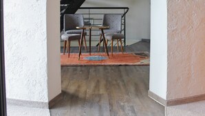 Un espace intérieur comprenant un escalier, deux chaises, une petite table et un tapis.