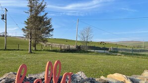 A stone wall with a 'hello' sign, a stone fence, and a grassy field with cows in the background. - The Old School Glasfryn | Dog Friendly | Betws y Coed 15 min | Ideal for Snowdon (Glasfryn)
