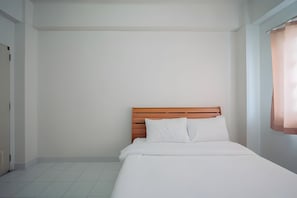 A single bed with a wooden headboard in a room with white walls and a tiled floor. - Oh My Nap Bangsaen (Chonburi)