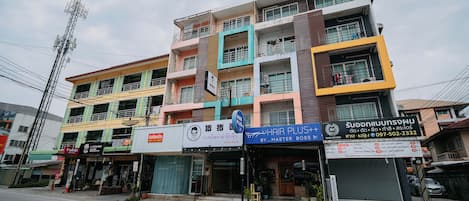 A multi-story building with various storefronts, including a hair salon and a shop with a sign in a foreign language.