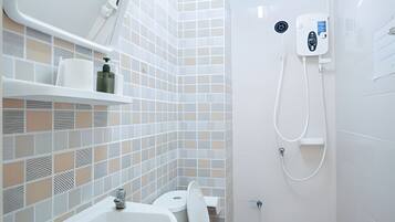 A bathroom with a toilet, sink, and shower.