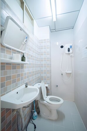 A bathroom with a toilet, sink, and shower.