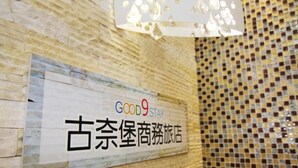 A wall with a sign that reads 'GOOD9STAY' and '古奈堡商旅酒店' in English and another language. - Good 9 Stay Inn (Taipei)