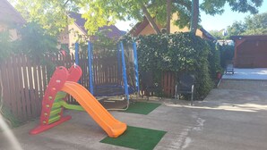 Un parque infantil con tobogán y columpios.