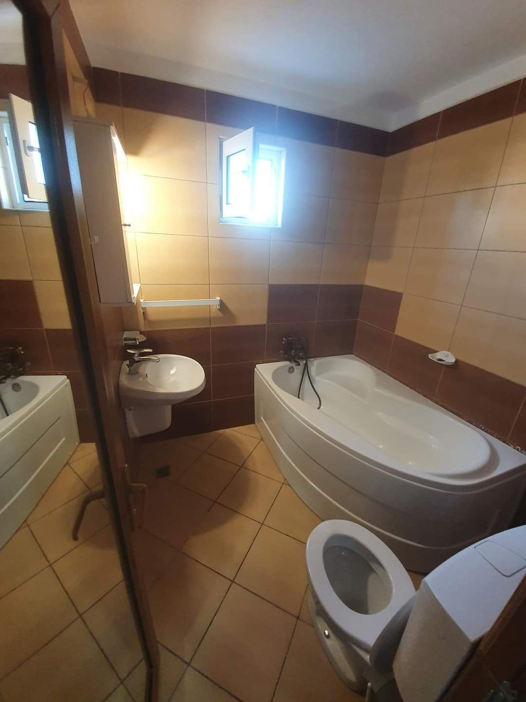 Un baño con bañera, inodoro y lavabo.